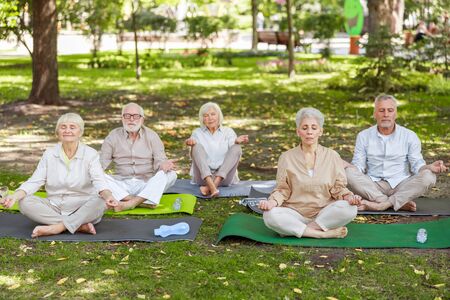 Older people meditating outside Older people meditating outside